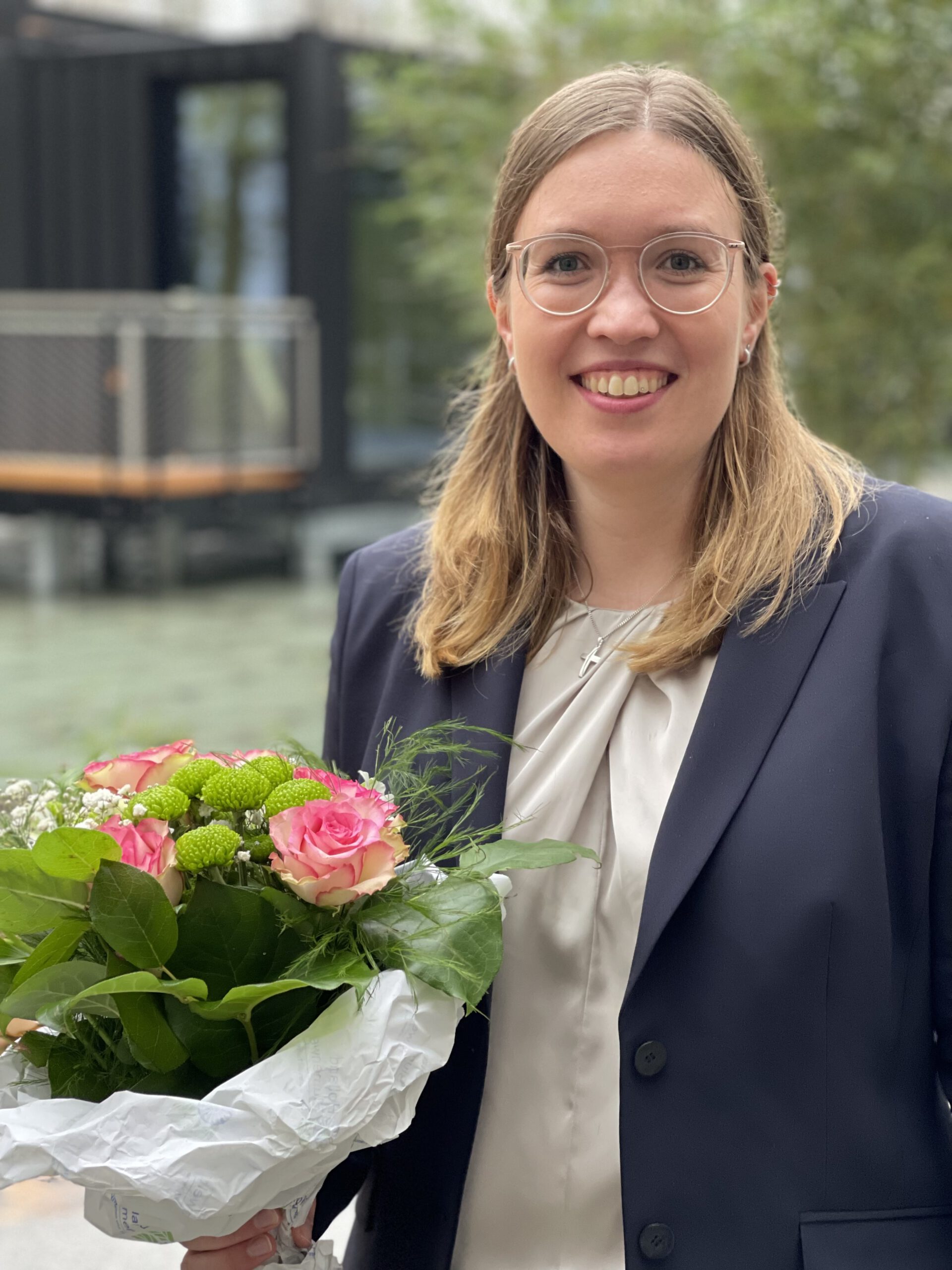 Bild von Veronika Fischböck mit einem Strauß Blumen in der Hand.